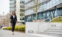 businesswoman-commuting-to-work-talking-on-mobile-phone-outside-modern-office-building.jpg